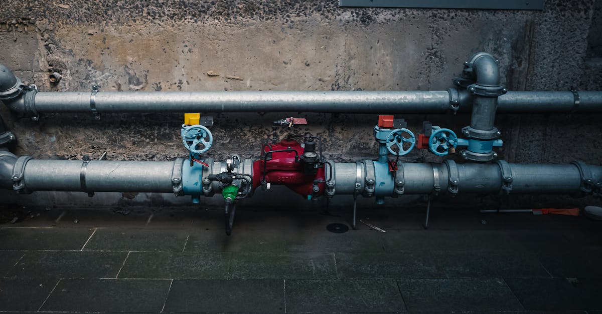 a detailed view of industrial pipes with colorful valves on a textured wall